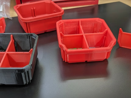 Red storage bins with a custom 4-space divider on a black surface