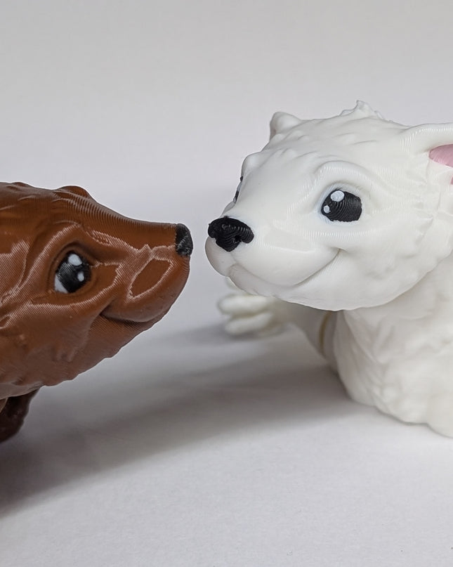 Two 3d printed toy ferrets one is brown and the other is white with pink ears on a soft white background