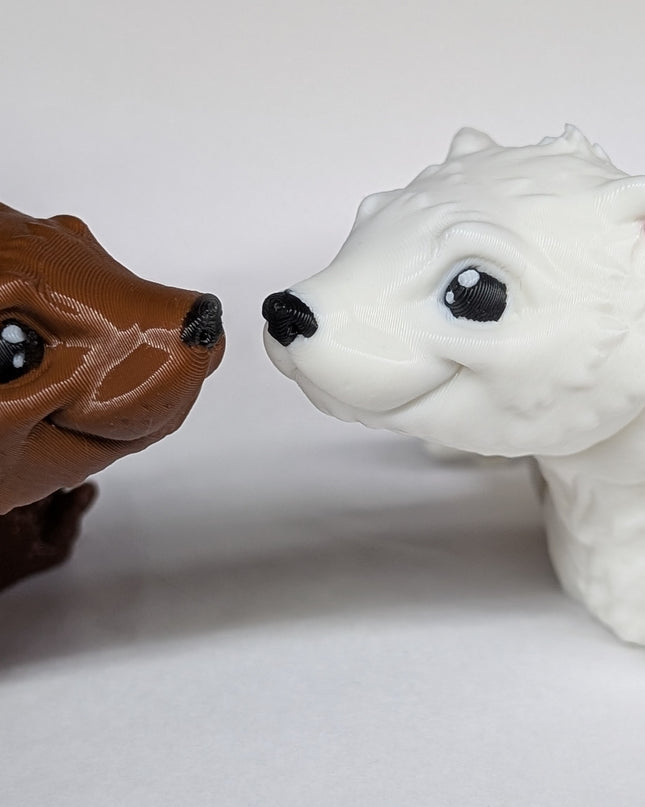 Two 3d printed ferret fidget toys nose to nose with each other. one is a shiny brown and the other is a soft white on a plain white background
