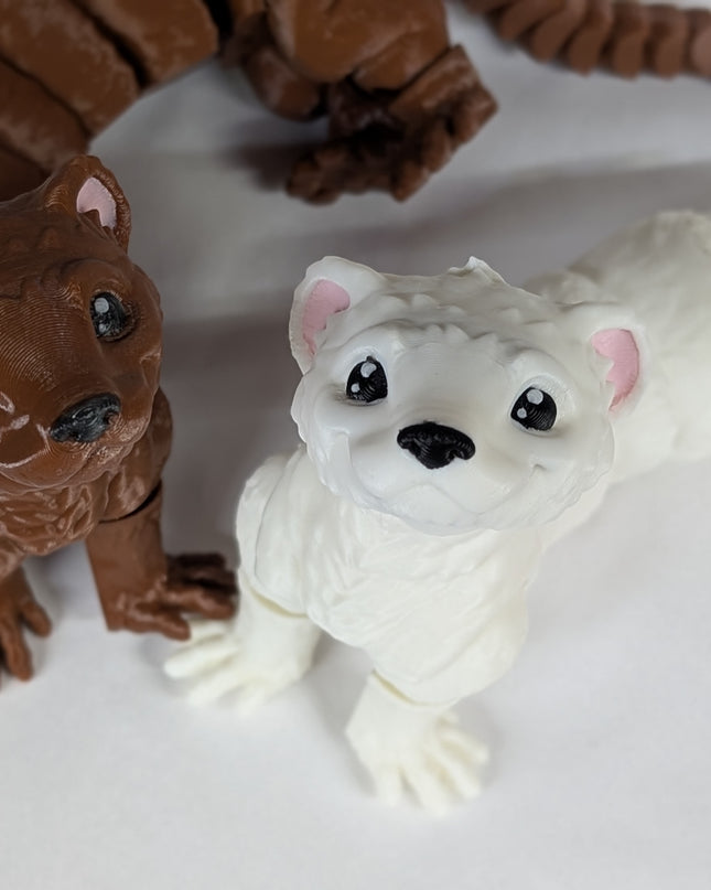 Two 3d printed toy ferrets one is brown and the other is white with pink ears on a soft white background