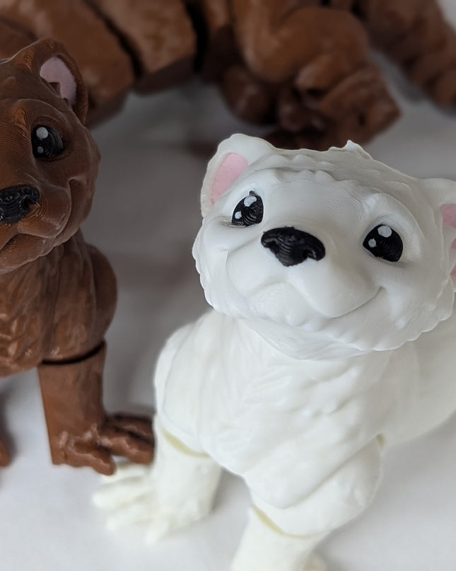 Two 3d printed toy ferrets one is brown and the other is white with pink ears on a soft white background