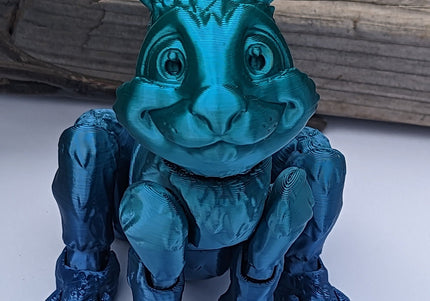 Blue ombre 3d printed jackalope with rabbit-like features on a white background with a wooden log 
