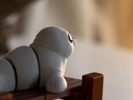 White toy seal on a wooden platform with a blurred background