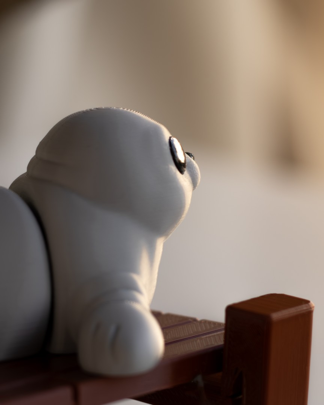 White toy seal on a wooden platform with a blurred background