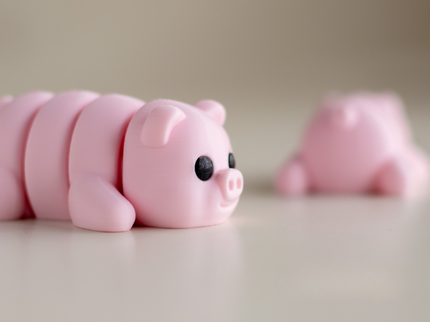 Two pink pig-shaped objects on a light background