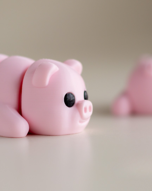 Two pink pig-shaped objects on a light background