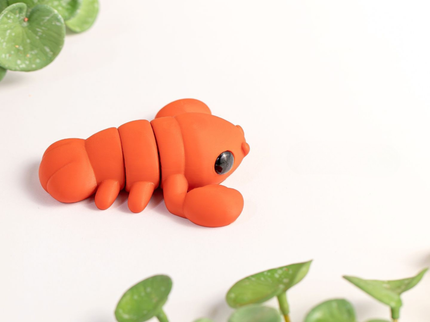 Orange Lobster toy with green leaves on a white background