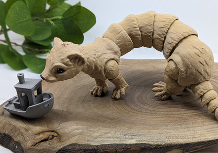 a 3d printed ferret playing with a small boat on a wooden surface with a green plant in the background