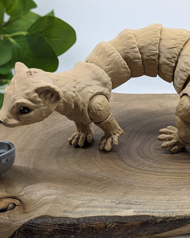 a 3d printed ferret playing with a small boat on a wooden surface with a green plant in the background