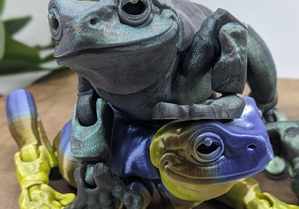 Two frog figurines stacked on top of each other with a natural background