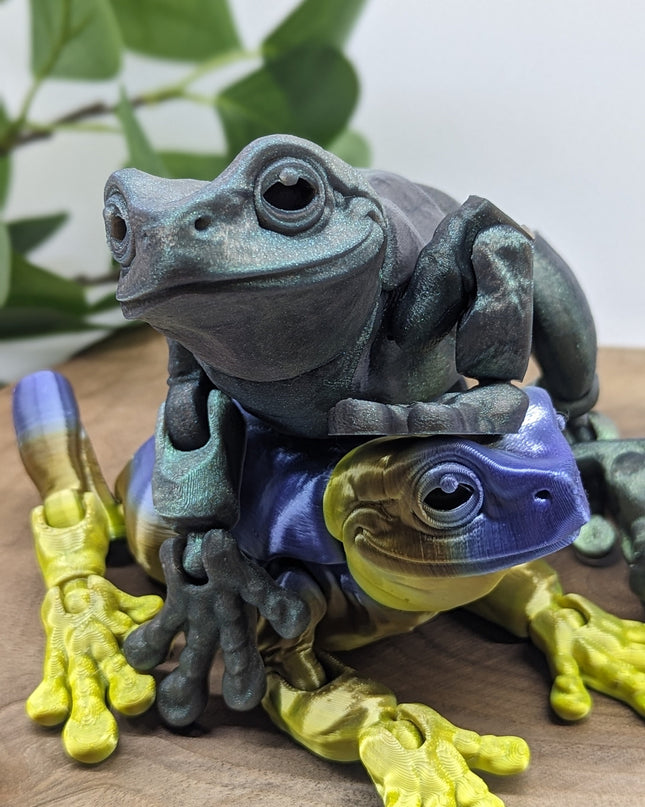 Two frog figurines stacked on top of each other with a natural background
