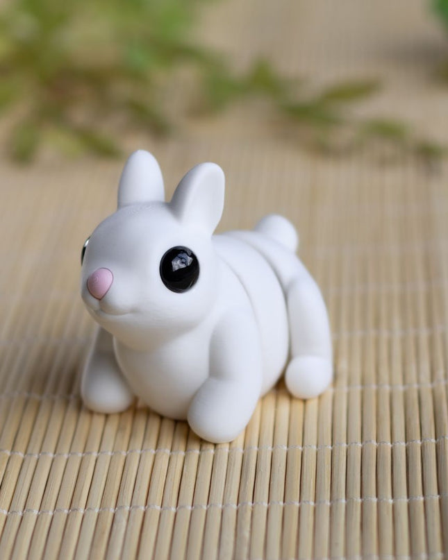 Small white dog figurine on a bamboo mat with greenery in the background