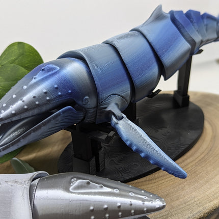 3d Printed Blue and gray humpback whale model on a stand with a natural background