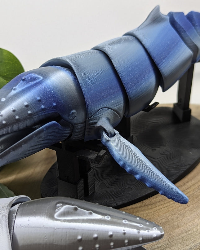 3d Printed Blue and gray humpback whale model on a stand with a natural background