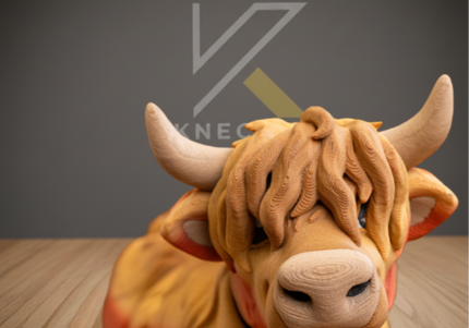 Cloe up of an articulated highland cow with a brand logo on a wooden floor