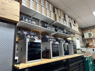Workshop area with shelves containing boxes and 3 3d printers