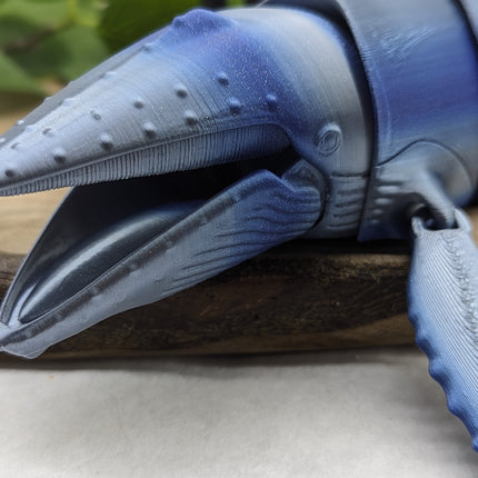 3d printed Blue and gray textured humpback whale head on a wooden surface.