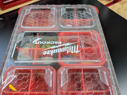 Clear plastic container with red accents featuring Milwaukee Tool logo