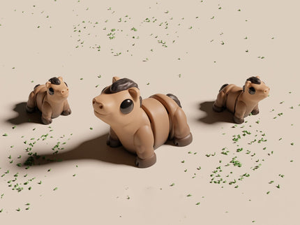 Three toy horses on a beige surface with scattered green leaves.