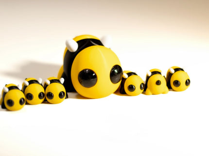 Toy bee family with a larger bee and smaller bees on a white background