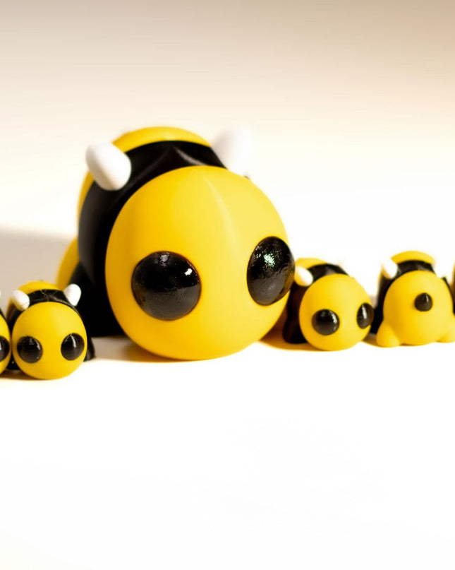 Toy bee family with a larger bee and smaller bees on a white background