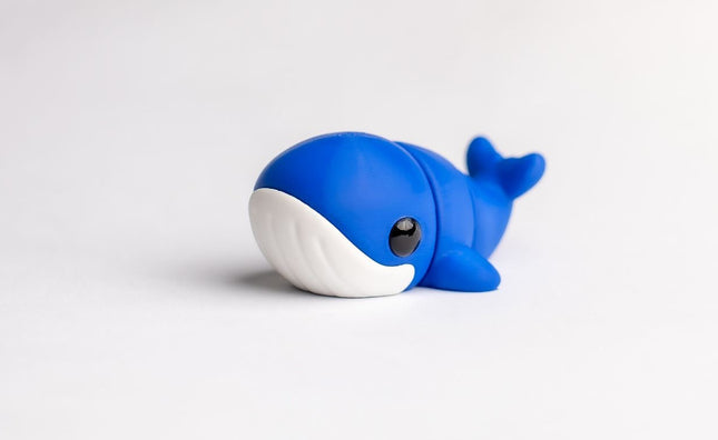 Blue toy whale on a white background