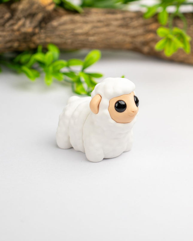 Small white figurine of a lamb on a light surface with greenery in the background