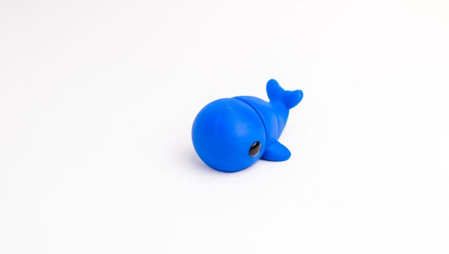 Blue articulated whale toy on a white background